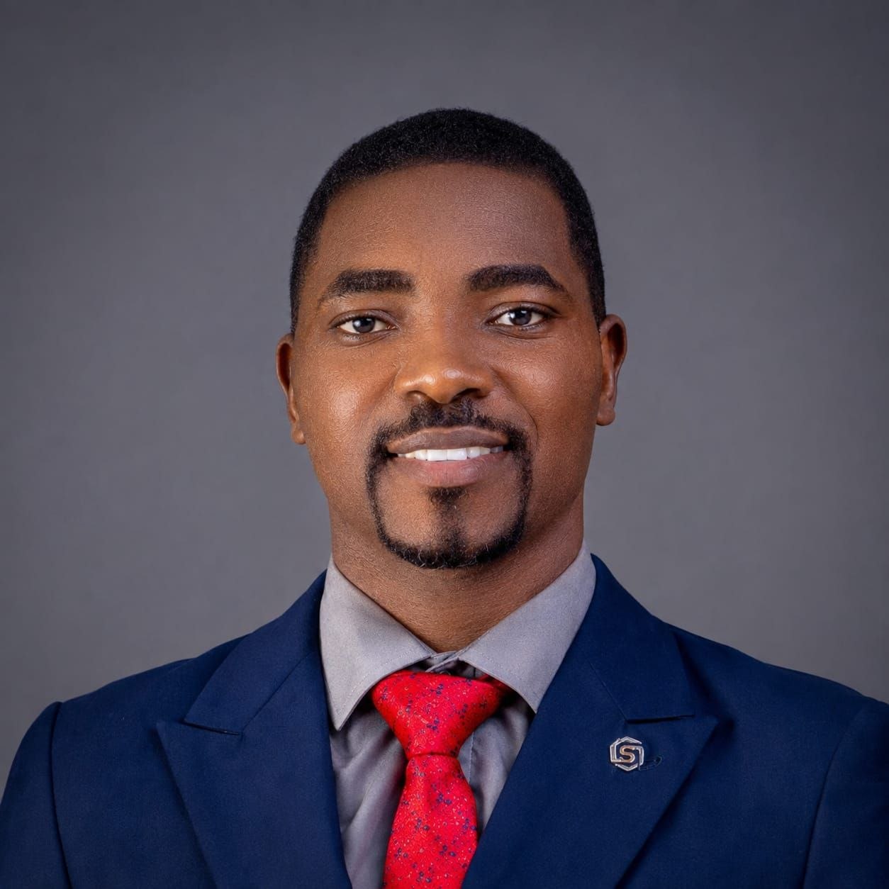 Portrait of Apostle Samson Paul Adeniran in a navy suit and red tie